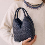 Canastos Indigo handwoven Colombian basket bag, carried with a cream sweater