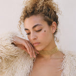 Gold Tierra choker, a flat-woven Miyuki seed bead choker, worn with a cream shaggy coat