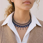 Okamas Vida Azul small beaded necklace in blue and navy, worn with a white collared shirt