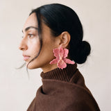 Orquideas pink beaded orchid earrings worn with a brown turtleneck