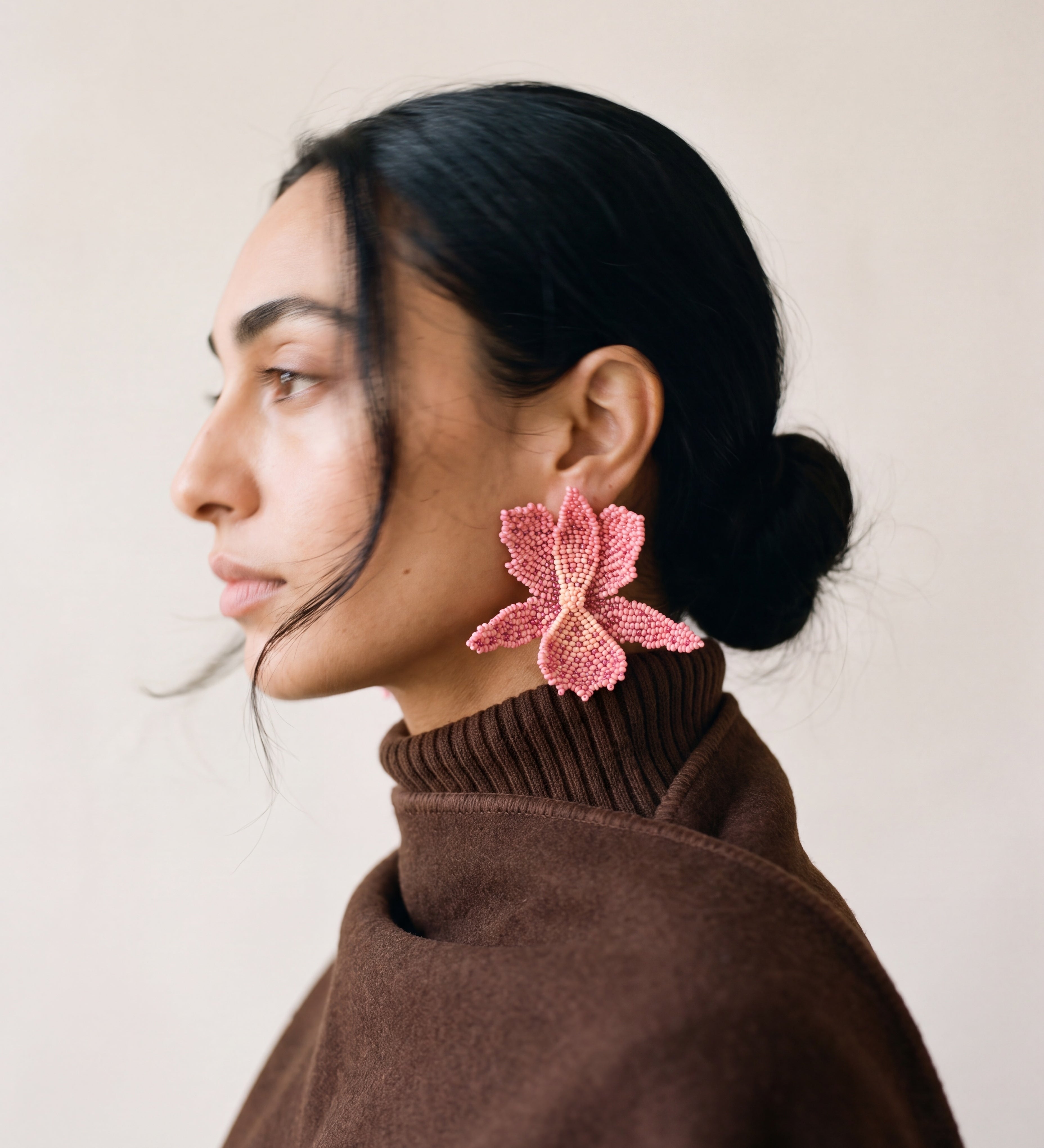 Orquideas pink beaded orchid earrings worn with a brown turtleneck